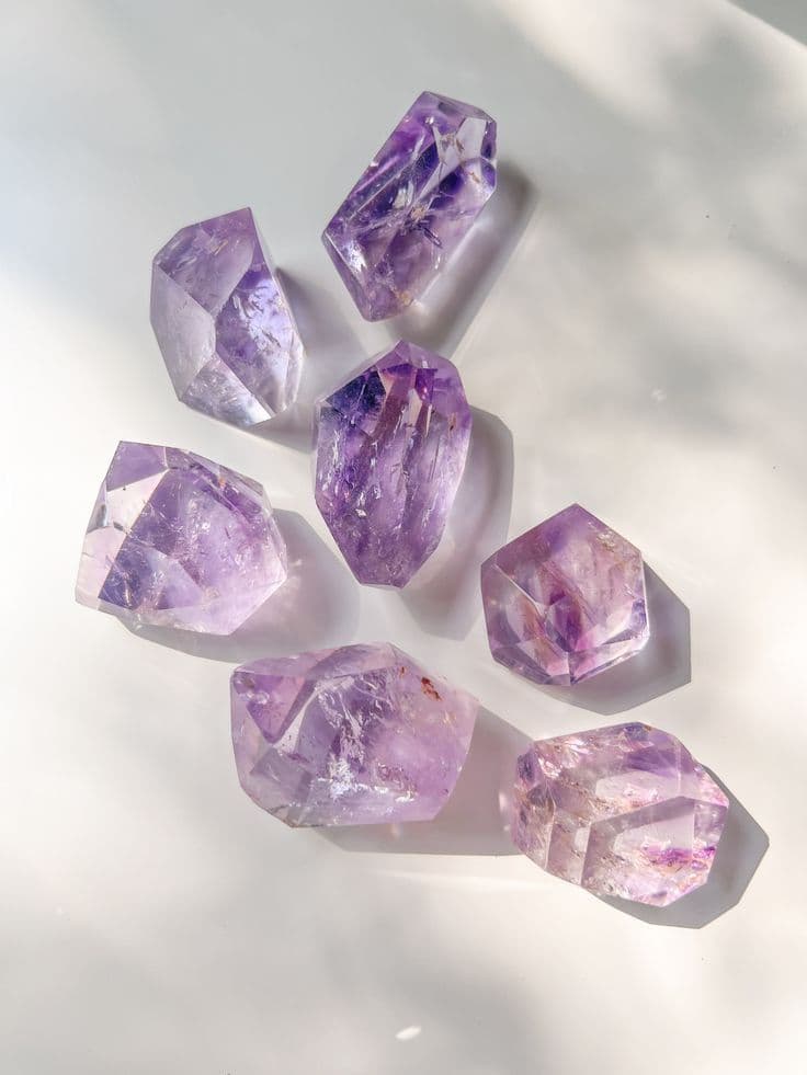 Amethyst crystal cluster with rich violet facets in cool meditative light.