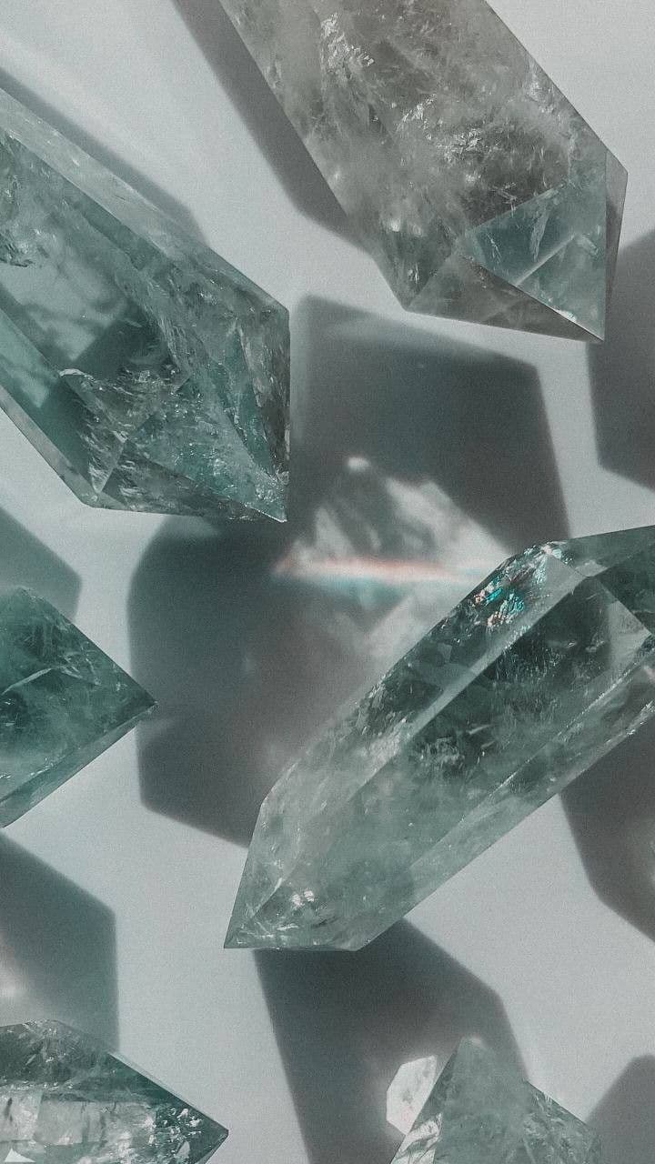 Fluorite crystal with translucent green-purple banding in cool light.