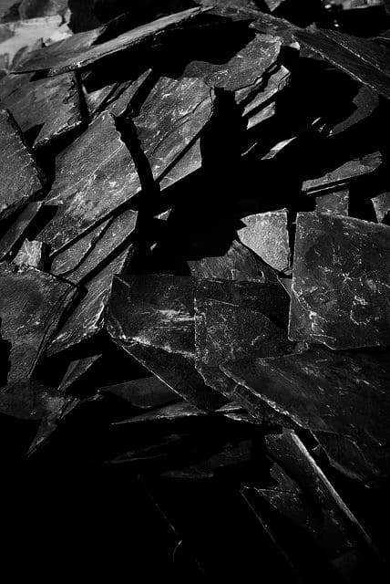 Obsidian stone with glossy black reflective surface and shadowy clarity.