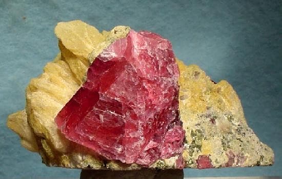 Rhodonite crystal with pink surface and dark grounding veins.